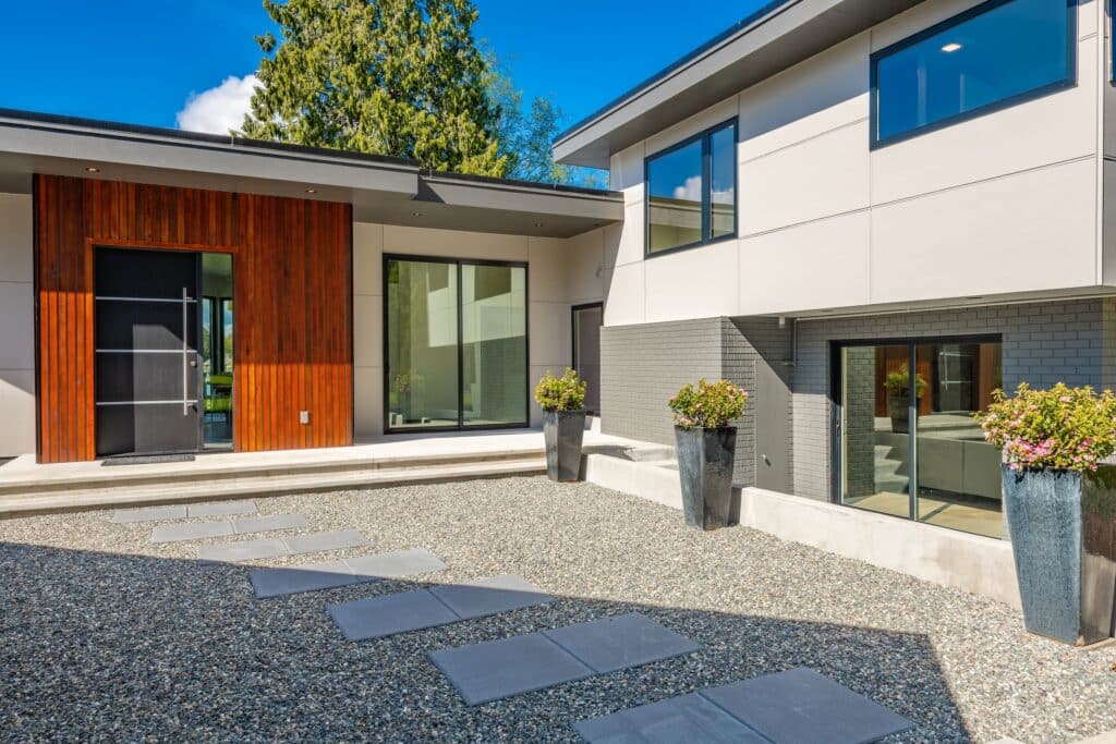 Contemporary home exterior on lakeshore with flat roof and large feature windows