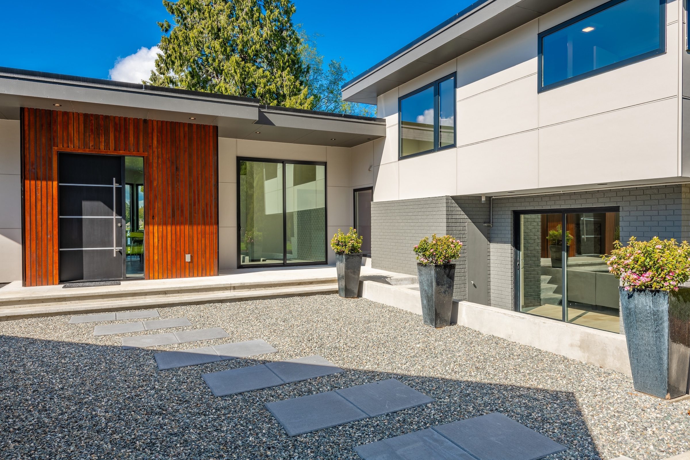 Contemporary home exterior on lakeshore with flat roof and large feature windows