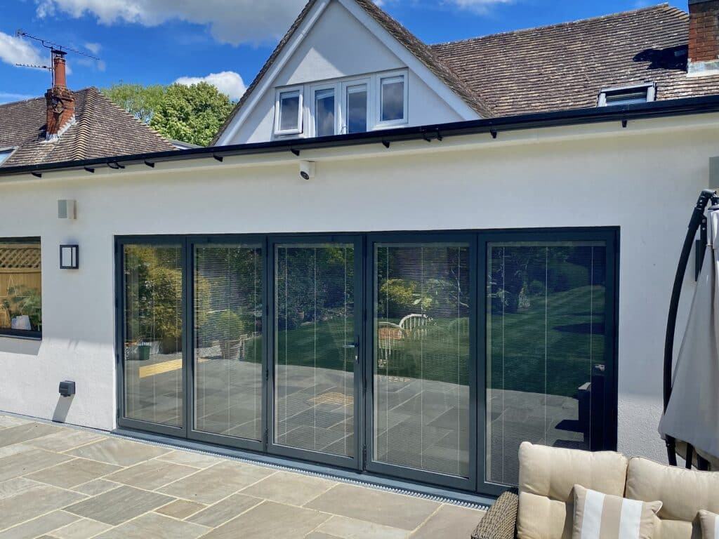 Alunet BF73 bifold doors grey colour, closed outside view with integral blinds.